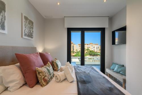 Un dormitorio con una cama con vistas a una ciudad. en Los Flamencos Isla Canela I, en Isla Canela