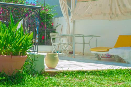 a patio with a table and chairs and plants at Villa avec piscine privée in Potinville