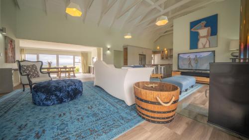 een woonkamer met een bank en een tafel bij Swallows Rest - Benguela Cove in Hermanus