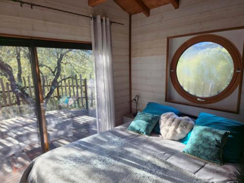 OmessaにあるGITES O FIL DE L'EAU piscine spa accès rivièreのベッドと大きな窓のある寝室