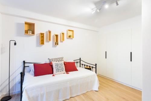 a bedroom with a white bed with red pillows at Casa da Se Cottage in Silves