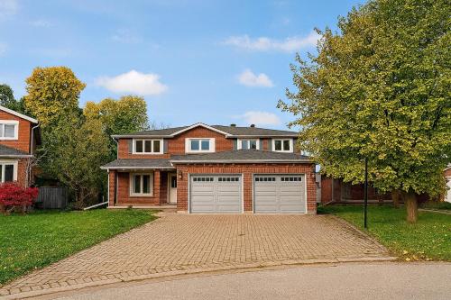 a brick house with two garage doors on a driveway at Luxury, Brand-new, Specious, 2-Bedroom Apartment in Richmond Hill