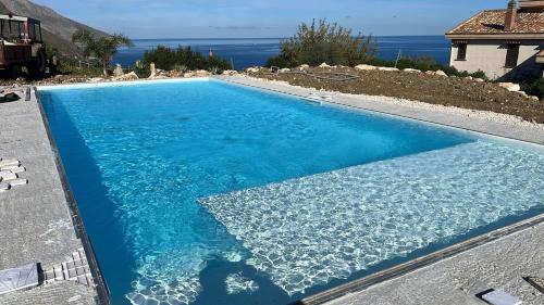 una piscina azul con vistas al océano en Apt Perterrepermari a 2 Km Da Riserva Dello Zingaro, en Scopello