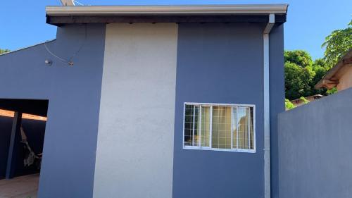 a blue and white building with a window at Ninho dos falcões in Nobres