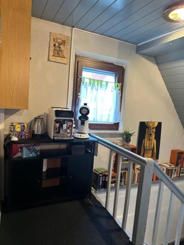 a room with a staircase with a microwave on a counter at Corner Haus Large Room in Schnaittach