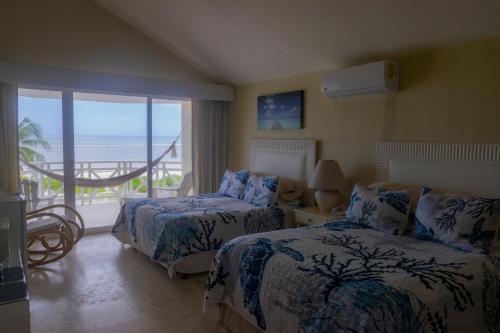 Un dormitorio con dos camas y vista al mar. en Puerta del Mar Cozumel, en Banco Playa