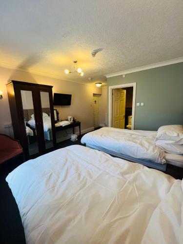 a bedroom with two beds and a mirror at Castle Hotel Tamworth in Tamworth