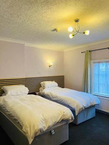 a bedroom with two beds and a window at Castle Hotel Tamworth in Tamworth
