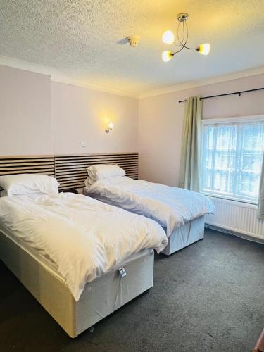 two beds sitting next to each other in a bedroom at Castle Hotel Tamworth in Tamworth