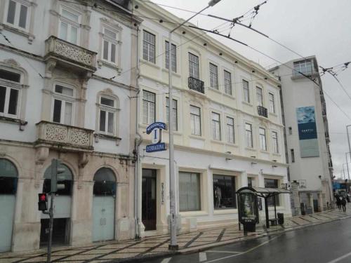 a large white building on a street with a bus stop at Internacional in Coimbra