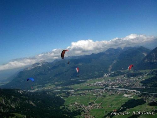 Un gruppo di aquiloni che volano nel cielo sopra una città di Landhaus Panorama a Reutte