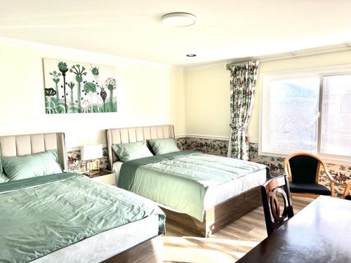 a bedroom with two beds and a table at Spacious Bedroom with Two Queen Sized Bed in Richmond