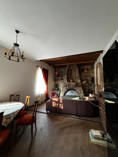 a living room with a large bed and a stone wall at Vintage Villa Mitskheta in Mtskheta