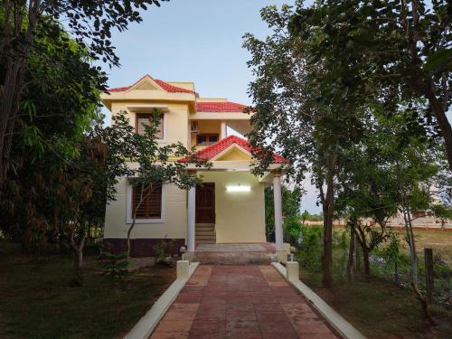 una casa blanca con una pasarela delante de ella en Neithal Illam, en Cheyūr