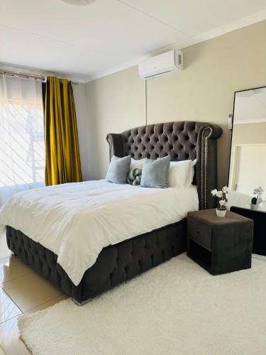 Un dormitorio con una cama grande con un cabecero grande. en Graceful Getaway Home, en Rundu