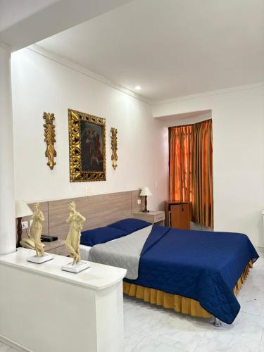 Un dormitorio con una cama con una manta azul. en Hotel Chucarima, en Cúcuta