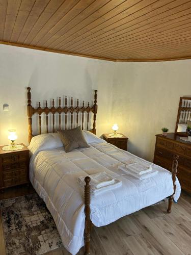 a bedroom with a large bed with two night stands at Cantinho da Aldeia in Castedo