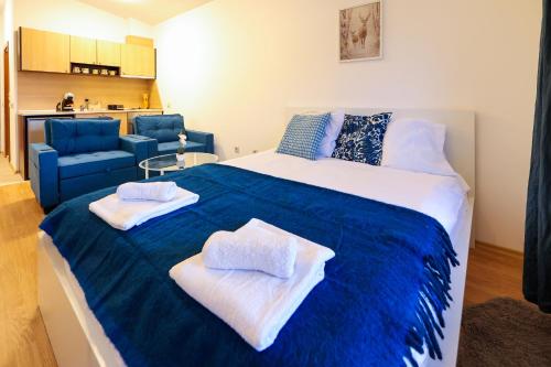 a bedroom with a large bed with towels on it at Blue Nest Studio - Free Parking and Mountain View in Razlog
