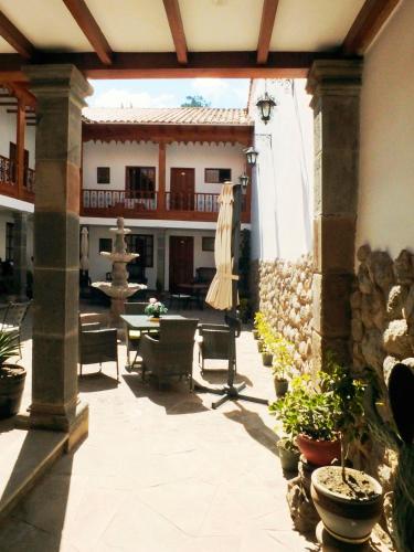 an outdoor patio with a table and a fountain at Illa Hotel in Cusco