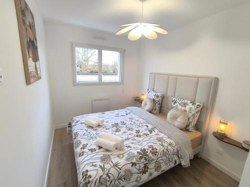 a bedroom with a large bed and a window at Le Zest d'or - Douceur & Lumière à 5min en voiture de la Plage in Biville-sur-Mer
