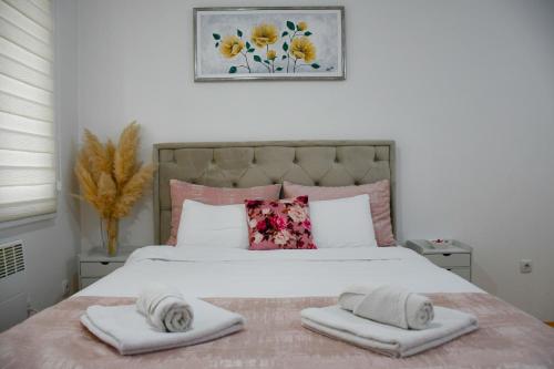 a bedroom with a large bed with towels on it at Apartman Boem Pale in Pale