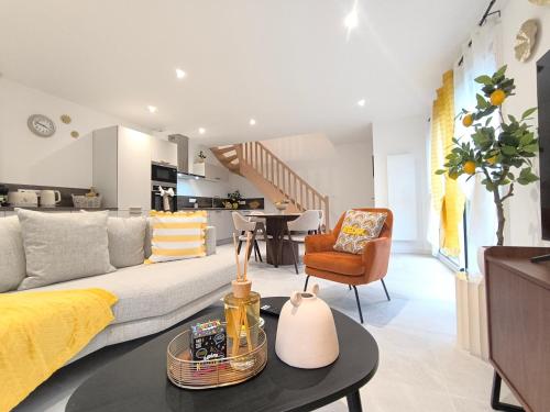 a living room with a couch and a table at Le Zest d'or - Douceur & Lumière à 5min en voiture de la Plage in Biville-sur-Mer