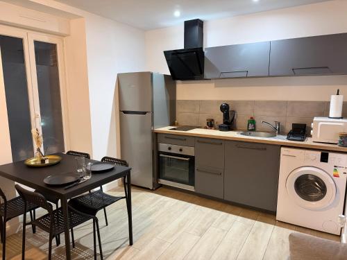 Comme chez soi في شاتوبرييا: مطبخ صغير به طاولة وثلاجة