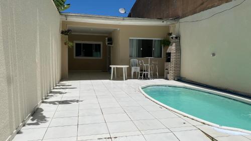 a patio with a swimming pool next to a house at Casa de 2 QUARTOS COM PISCINA in Balneário Camboriú