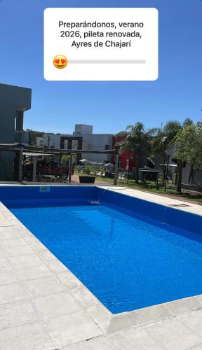 a screenshot of a text message about a blue swimming pool at Ayres de chajari in Chajarí
