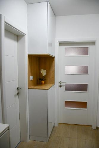 a kitchen with white cabinets and a door at Apartman Boem Pale in Pale
