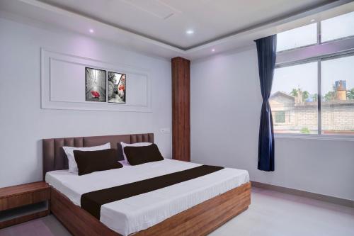 Hotel O Happy Homes Resort في Kāhārpāra: غرفة نوم بها سرير ونافذة كبيرة