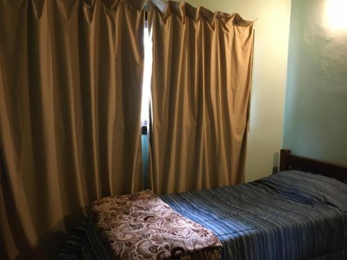 ein Schlafzimmer mit einem Bett und einem Fenster mit Vorhängen in der Unterkunft Casa en La Caleta Mar de Cobos in Mar de Cobo