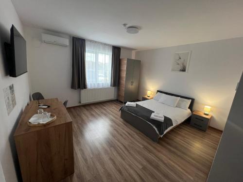 Un dormitorio con una cama y un escritorio. en Salin Home, en Ocna-Mureşului