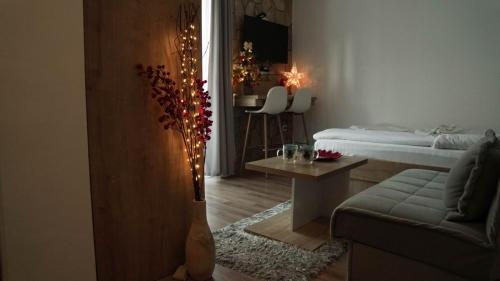 Una sala de estar con una cama y una mesa con luces. en Hop Kop, en Kopaonik