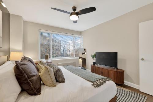 a bedroom with a bed and a flat screen tv at CASA Arlington Suite with In-Suite Massage Chair & Premium Amenities in Arlington