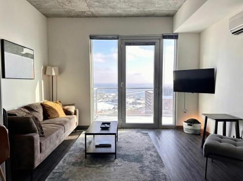un soggiorno con un divano e una TV di Luxury Penthouse Apt Near Brady St with Balcony and Lake View a Milwaukee