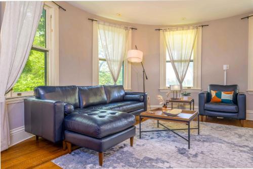 a living room with a leather couch and chairs at Westcott Suite Apartments in Syracuse