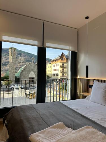 a bedroom with a bed and a large window at El tossalet Hotel - Apartament in El Pont de Suert