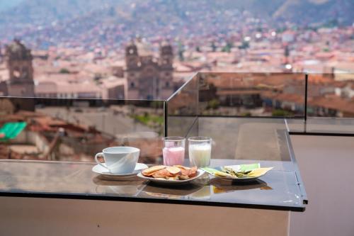 Una mesa con un plato de comida y un vaso de agua y una bebida. en Hostal Casa Del Inka, en Cusco