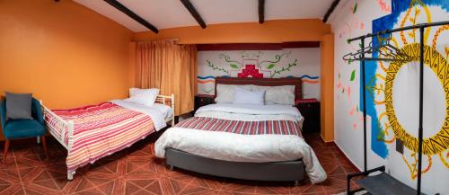 Un dormitorio con dos camas y un mural en la pared. en Hostal Casa Del Inka, en Cusco