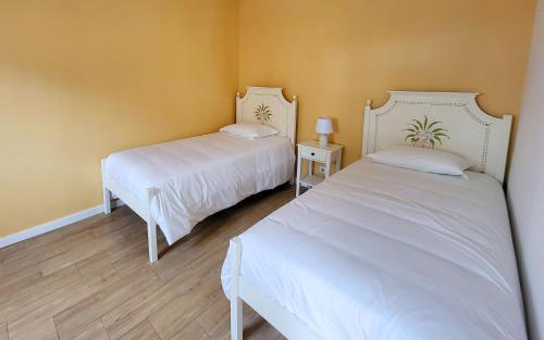 - 2 lits blancs dans une chambre aux murs jaunes dans l'établissement Casa Elvas Antiqua, à Elvas