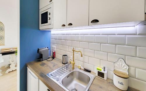 une cuisine avec un évier et un micro-ondes dans l'établissement Casa Elvas Antiqua, à Elvas