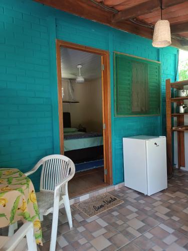モヘチスにあるCasinhas do Rio - Casinha Azul na Florestaのテーブルと椅子と冷蔵庫のある青い部屋
