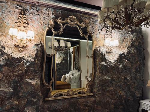 espejo ornamentado en la pared del baño en Conacul Coroanei Luxury Boutique Hotel, en Bucarest