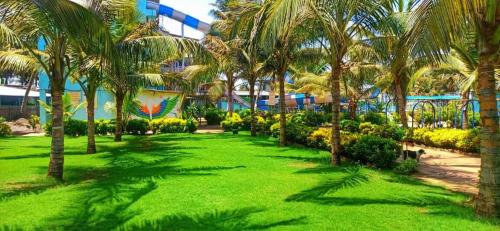 a park with palm trees in front of a building at Dreamworld Waterpark Resort Virar in Virār