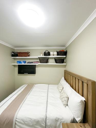 a bedroom with a bed with white sheets at 29 on Windsor-2 Bedroom House in Silver Sands
