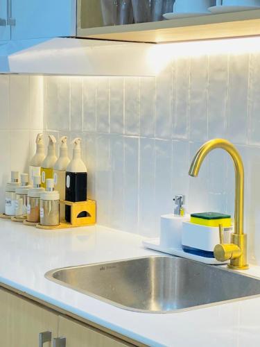a kitchen counter with a sink and a counter top at Simple White Scape at Mesavirre Bacolod in Bacolod