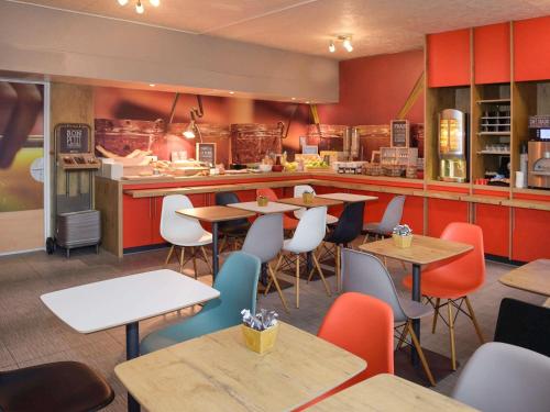 um restaurante com mesas e cadeiras e um balcão em ibis Lyon Gerland Merieux em Lyon