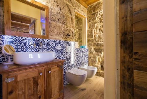 a bathroom with a sink and two toilets at Grand Suite Gioberti Elegante nel cuore di Alghero in Alghero