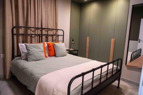 VASIADIS apartment في Síndos: غرفة نوم مع سرير مع وسائد برتقالية ورمادية